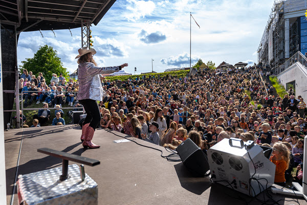 Onkel Reje står på scenen foran et stor publikum ved Kulturhuset.